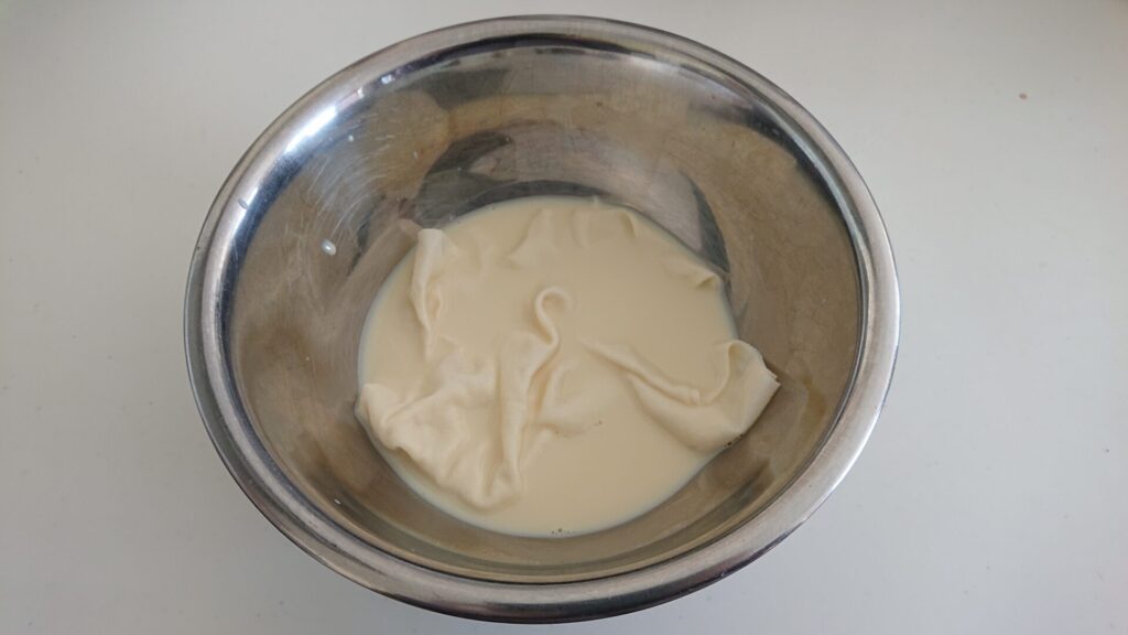 綿をボウルに入れ前処理剤の豆乳に浸けている写真